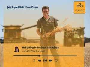 WA grain farmer Ash Wiese holding a bundle of harvested grain in a broadacre paddock, featured on Triple M Rural Focus discussing five years of using C-Wise compost